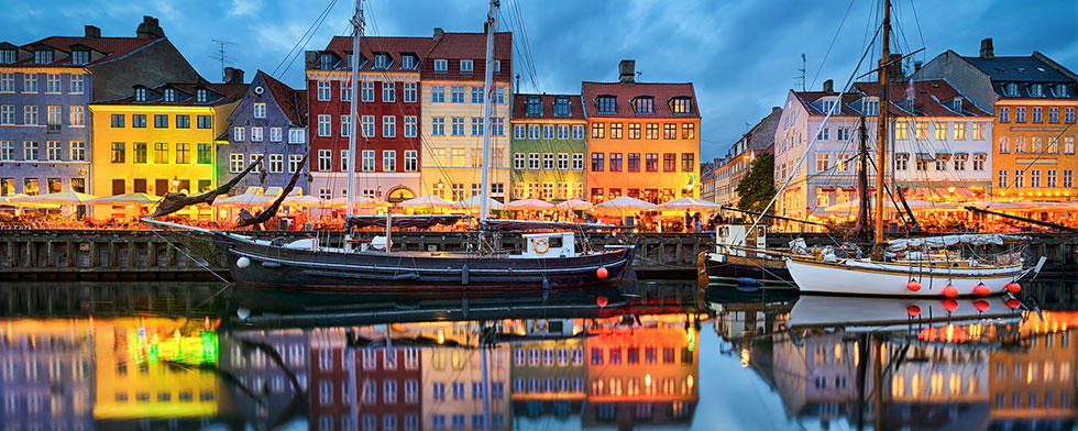 Copenhagen row houses glowing on the water at night